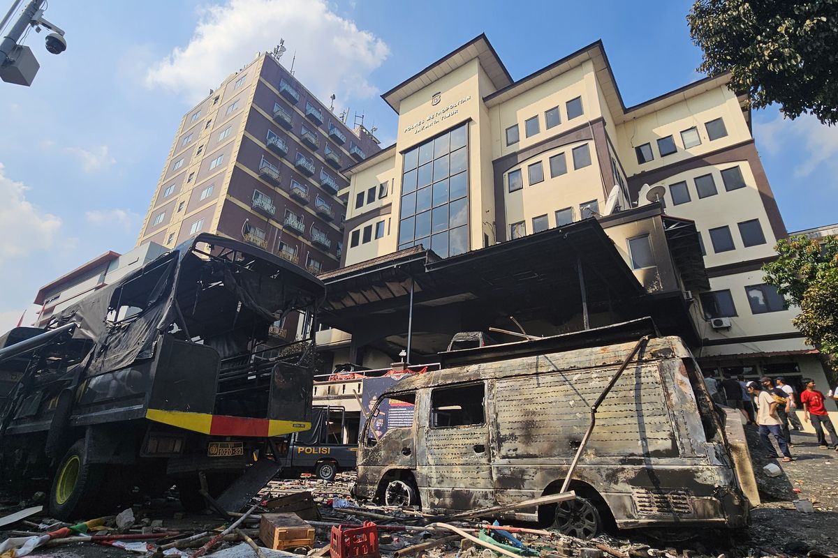 Warga mengamati kendaraan dinas kepolisian yang hangus terbakar di Mapolres Jakarta Timur, Sabtu (30/8/2025). (ANTARA FOTO/Muhammad Iqbal). Kerusuhan dalam aksi unjuk rasa menyebabkan puluhan mobil dinas dan sejumlah ruangan di Mapolres terbakar. Peristiwa ini menyoroti kerentanan institusi penegak hukum di tengah dinamika sosial dan politik yang kian memanas.